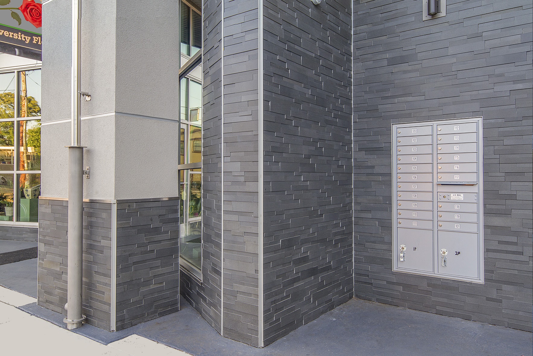 Norstone Grey Aksent 3D Stone Veneer with metal mailbox, downspout and corner accents